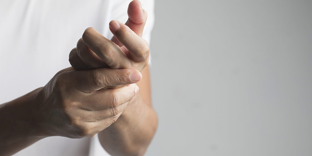 Man checks hand for loss of feeling due to neuropathy