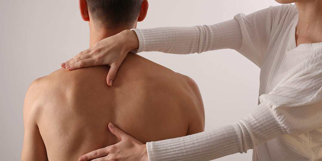 Man has back inspected before treatment is administered